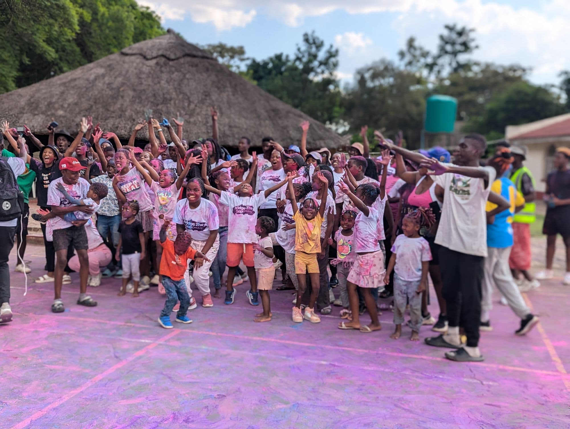 The church family with arms raised on the colour day