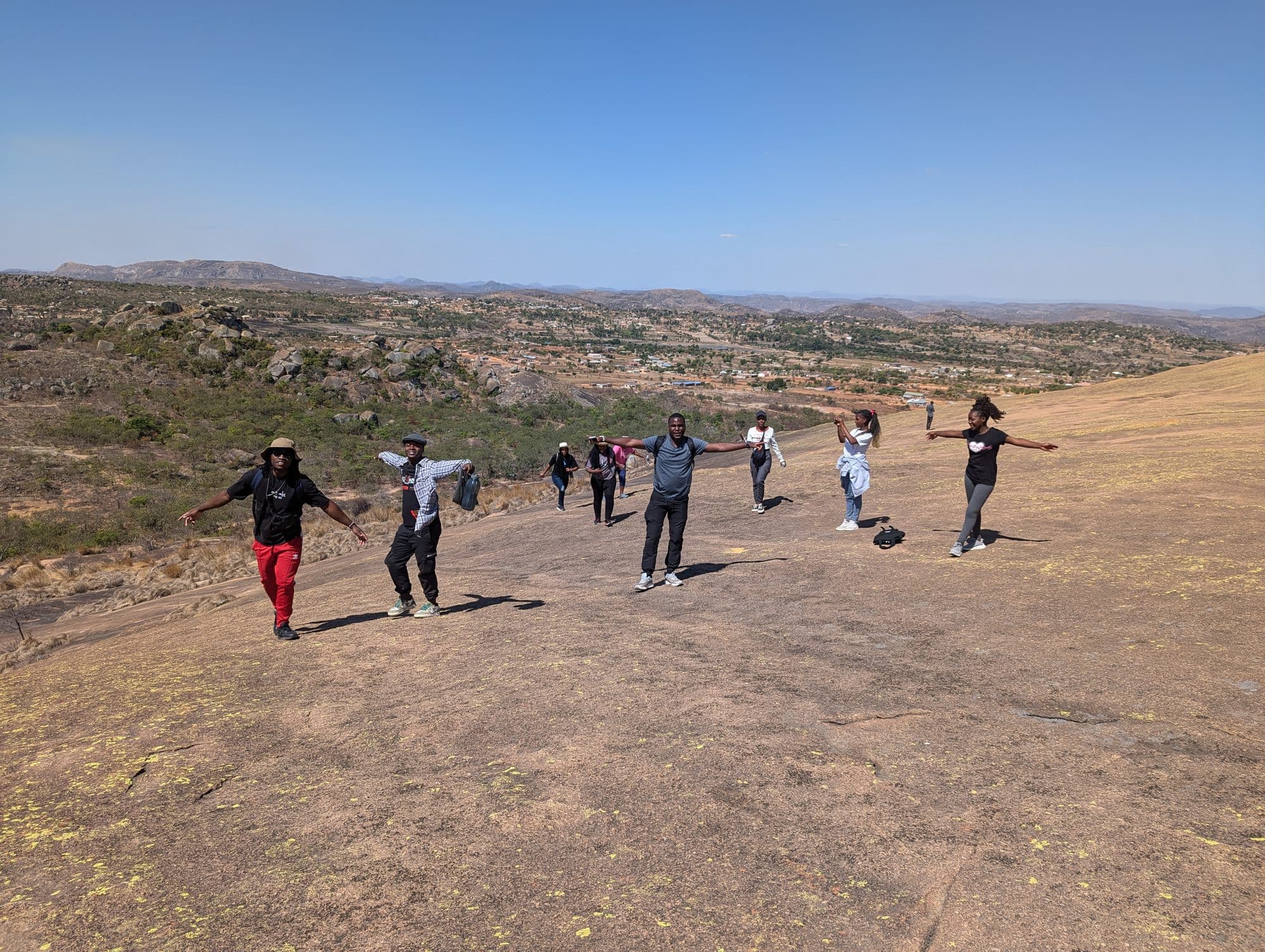 The congregation spread across a granite kopje under a wide sky